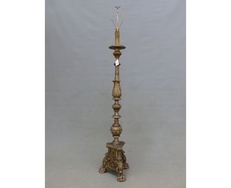 A BAROQUE STYLE SILVERED WOOD STANDARD LAMP CARVED WITH FOLIAGE AND FLUTED ABOVE A TRIANGULAR BASE ON THREE PAW FEET.   H 158