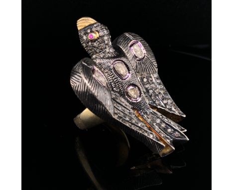 A POLKI DIAMOND SET LARGE BIRD RING, THE LARGE CARVED BIRD IN SILVER WITH A SILVER GILT SHANK. RUBY EYES, DIAMOND SET WINGS A
