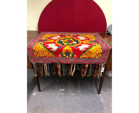 A SINO TIBETAN COLOURED BAIZE APPLIQUE PANEL WORKED WITH THE WHEEL OF DHARMA ENCLOSED BY FOUR BUDDHIST LIONS AND BLUE THUNDER