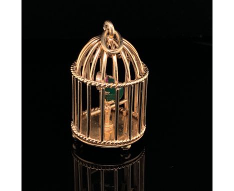 A 9ct GOLD BIRDCAGE PENDANT. INSIDE THE CAGE PERCHES A STONE SET PARROT WITH A GREEN JADE BODY, AND A FACET RUBY EYE. HALLMAR