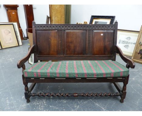 AN ANTIQUE AND LATER OAK CARVED PANEL BACK SETTLE.  TURNED SUPPORTS WITH BARLEY TWIST FRONT STRETCHER.  H. 108 x W. 140 x D. 
