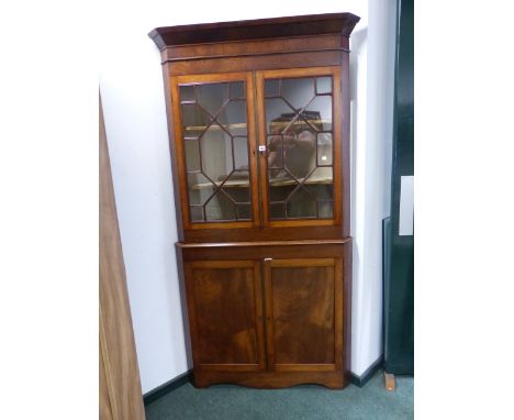 A 19th C. MAHOGANY CORNER CUPBOARD THE UPPER HALF WITH ASTRAGAL GLAZED DOORS OVER SHELVES, THE BASE WITH PANELLED DOORS CLOSI