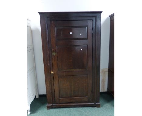 AN 18th C. OAK CUPBOARD WITH THE THREE PANELLED DOOR ENCLOSING HANGING SPACE ABOVE A SHELF AND THE SHALLOW BRACKET FEET.   W 