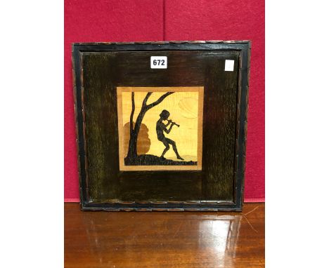 A ROWLEY GALLERY LABELLED MARQUETRY PANEL DEPICTING A YOUTH PLAYING A PIPE BELOW A TREE IN EBONY AGAINST LIGHTER WOODS.   34 