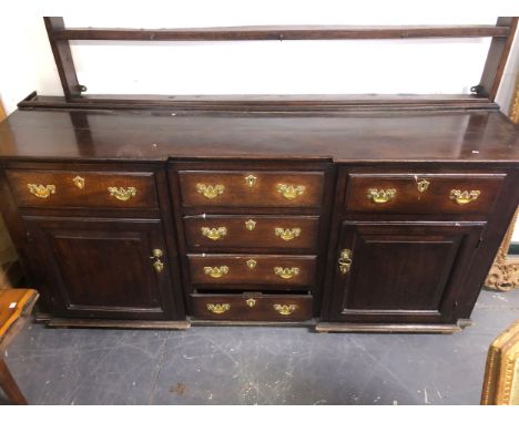 AN 18TH CENTURY COUNTRY OAK DRESSER BASE WITH CENTRAL DRAWERS AND PANEL SIDES.