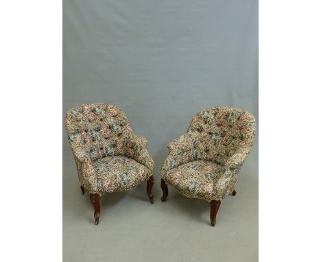 A PAIR OF CARVED WALNUT BUTTON BACK TUB FORM VICTORIAN ARMCHAIRS.  H. 88 x W. 74 x D. 82cms.
