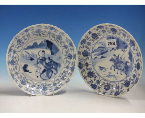 A PAIR OF CHINESE BLUE AND WHITE DISHES, THE FLUTED RIMS PAINTED WITH SCROLLING LOTUS ENCLOSING HUNTING SCENES, SIX CHARACTER