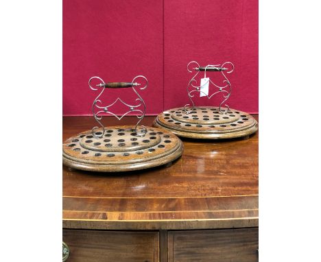 A PAIR OF EDWARDIAN OAK OVAL SHOT GLASS CARRIERS WITH CENTRAL ELECTROPLATE BRACKET AND TURNED WOOD CARRYING HANDLES.   W 40cm