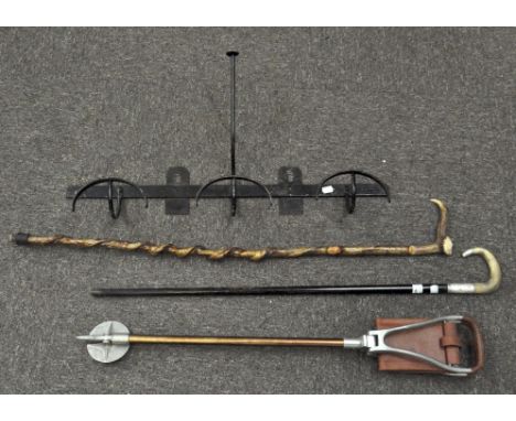 A vintage shooting stick together with a silver collared, horn handled walking cane, an iron coat rack and another walking st