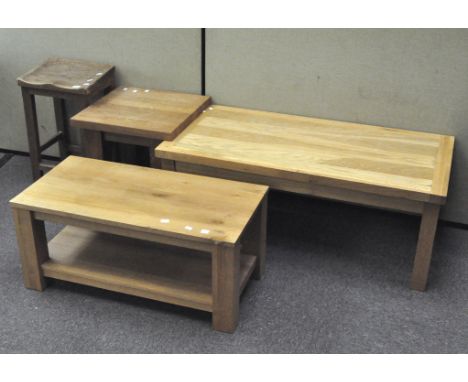 A vintage oak stool with angled seat, 61cm high, together with three modern light wood side tables, largest 120cm wide