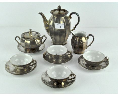 An Art Deco silver on porcelain part coffee set comprising 17cm coffee pot, cream, sugar, four coffee cups and 5 saucers.