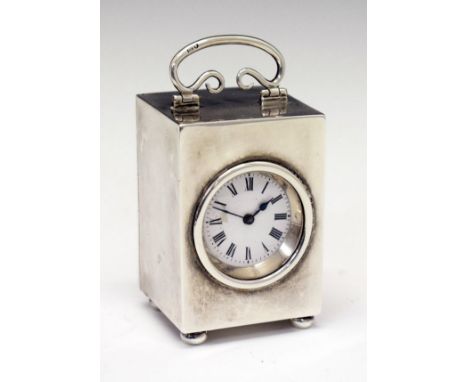 George V silver cased miniature carriage clock, the white enamel dial with Roman numerals, handle to the top and standing on 