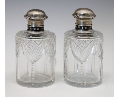Pair of early 20th Century Fabergé cut glass scent bottles, having pull-off silver tops with embossed decoration, each marked