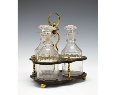 Regency brass mounted black lacquered trefoil shaped decanter stand having a central loop handle and standing on ball feet, c