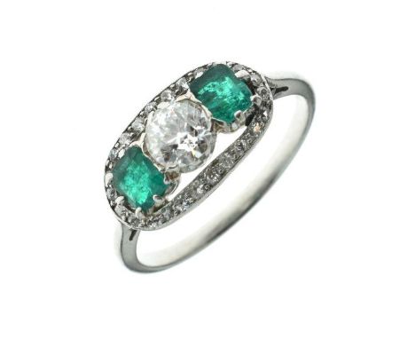 Diamond and emerald three stone ring, the central old brilliant cut of approximately 0.5 carats, flanked either side by a ste