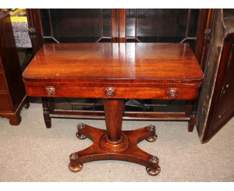 A Victorian rosewood card table,&nbsp;the rectangular fold over swivel top raised on octagonal tapering column, quatrefoil ba