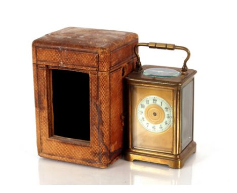 A brass carriage clock,&nbsp;with striking gong movement, circular enamel dial, 12cm high with outer carrying case AF