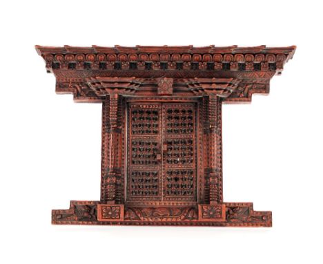 A late 19th Century Chinese carved wooden architectural frame,&nbsp;the pagoda type edge and twin opening doors flanked by cl