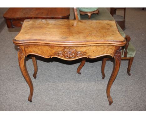 A 19th Century walnut serpentine card table,&nbsp;the fold over top raised above floral carved shaped frieze and cabriole sup