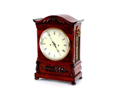 A 19th Century rosewood bracket clock,&nbsp;with carved foliate decoration, arched top above a circular enamel dial, 8 day mo