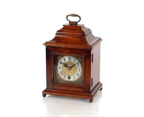 A mahogany miniature bracket clock,&nbsp;in the George III style surmounted by a brass carrying handle above an ogee moulded 