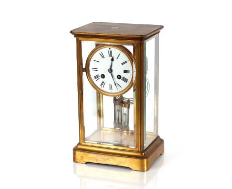 A 19th Century brass four glass mantel clock,&nbsp;with circular white enamel Roman numeral dial supporting an eight day move
