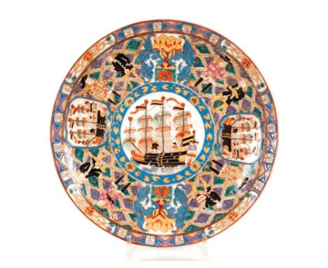 A Chinese saucer dish,&nbsp;decorated with a central sailing ship panel within a Western figure and ship border, red square s