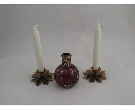 A ruby glass oil lamp together with a pair of brass candle holders 