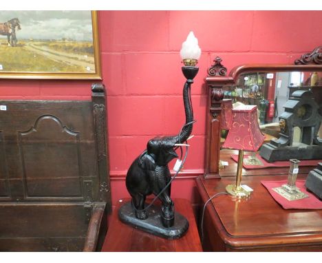 An ebonised hardwood elephant form lamp with flami form shade, 92cm tall 
