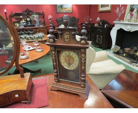 A carved mantel clock with owl finial, ormolu mounts of mask and figures 