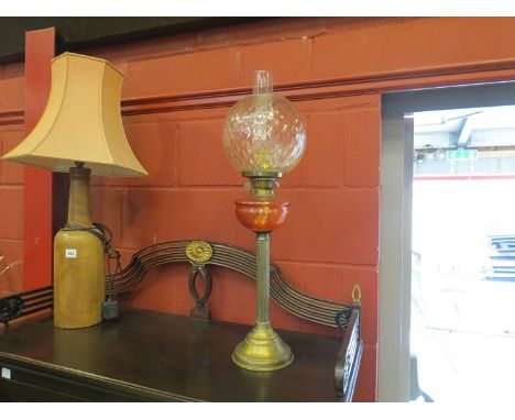 A Victorian brass oil lamp with clear crosshatch shade over peach glass reservoir, reeded column 