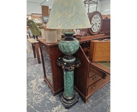 A ceramic table lamp standing on matching pedestal stand.