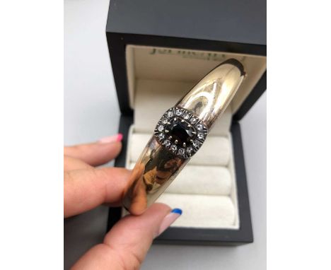 An antique garnet and old cut diamond hinged bangle, the clasp tongue stamped 15, assessed as 15ct gold. Widest point interna