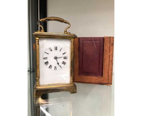 A brass-cased carriage clock and travelling outer leather case.