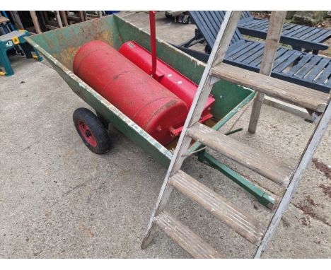 A small tractor trailer,  a roller attachment and a wooden step ladder