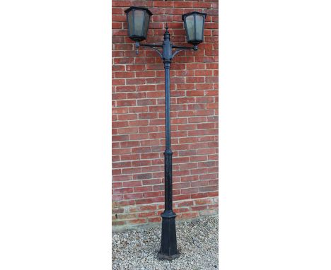 A BLACK PAINTED ALUMINIUM TWO LIGHT STREET LANTERN with turned column support and a hexagonal spreading base, approximately 2