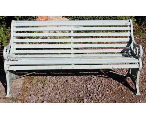 A PALE GREEN PAINTED GARDEN BENCH with cast iron ends and with thistle, rose, shamrock and fleur de lys design and a slatted 