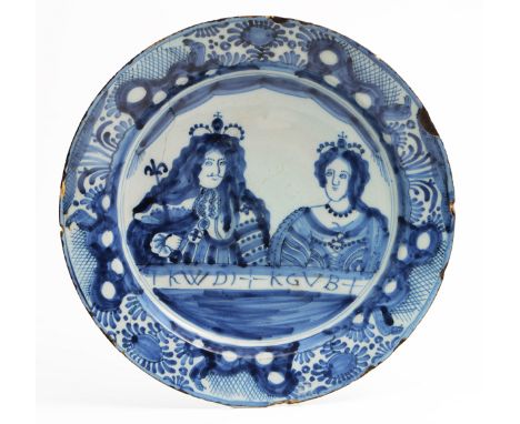A LATE 18TH CENTURY DUTCH DELFTWARE CHARGER decorated with a portrait of King William III and Queen Mary, over lettering 'KWD