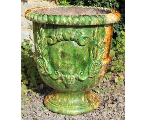 A FRENCH GREEN AND BROWN GLAZED GARDEN PLANTER with rope twist edge and moulded decoration to the body on a circular base, 52