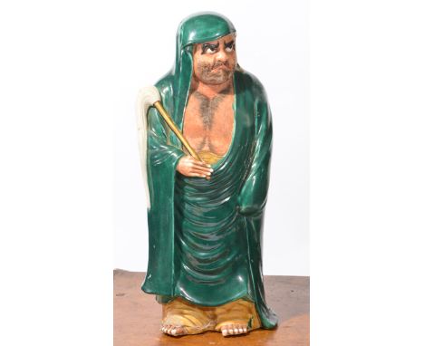 AN EASTERN PORCELAIN MODEL OF A BEARDED MAN IN A GREEN CLOAK, 43cm in height