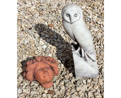 A CAST SCULPTURE OF A BARN OWL resting on an angled perch, 37.5cm high, together with a small terracotta wall bracket of a gi