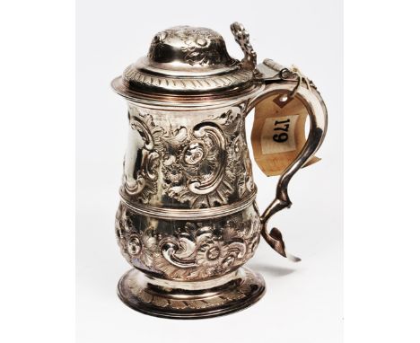 A GEORGE III SILVER LIDDED TANKARD with a domed top, pierced scrolling thumbpiece and  baluster body on a spreading circular 