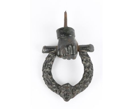 A 19TH CENTURY CAST IRON DOOR KNOCKER in the form of a fist holding a laurel wreath with lion mask, 15.5cm wide