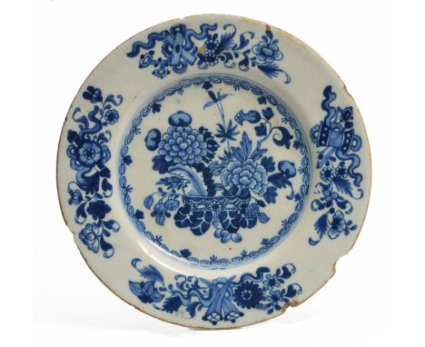 A GEORGE III IRISH DELFTWARE PLATE decorated in cobalt blue with a vase of flowers and lucky symbols to the rim and inscribed