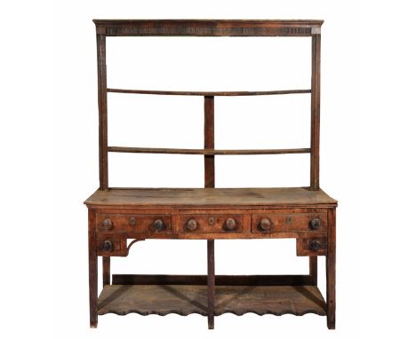 A GEORGE III OAK DRESSER with two shelf plate rack above, the base with three drawers, each with turned knob handles and two 