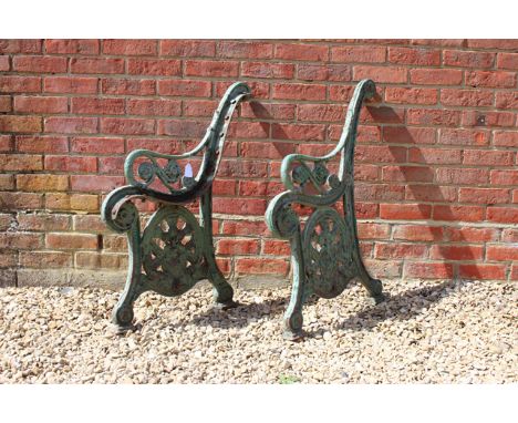 A PAIR OF VICTORIAN CAST IRON GREEN PAINTED BENCH ENDS with foliate decoration, 88cm high