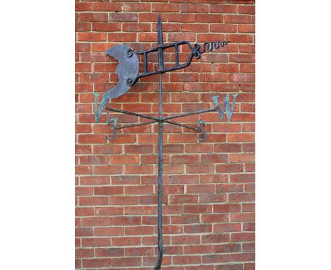 AN OLD BLACK PAINTED WROUGHT IRON WEATHER VANE, the rotating indicator decorated with a 'man in the moon' mask above the four