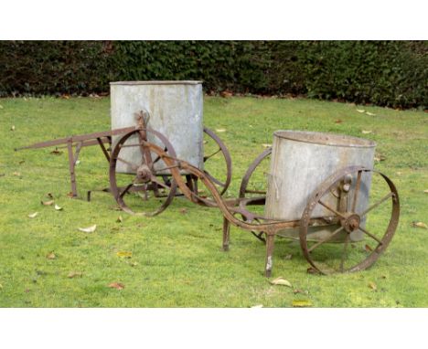 Water Feature: A wrought iron and galvanised zinc water bowser  Edwardian 130cm long, together with another water bowser