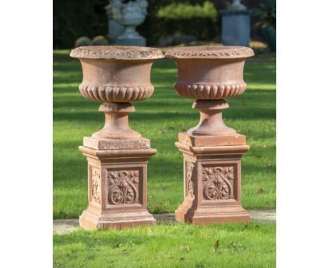 Planter: A pair of terracotta urns on pedestals  early 20th century 90cm high