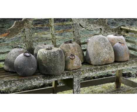 Architectural: A harlequin set of ten granite and stone weights  18th/19th century with iron ring handles 34cm high